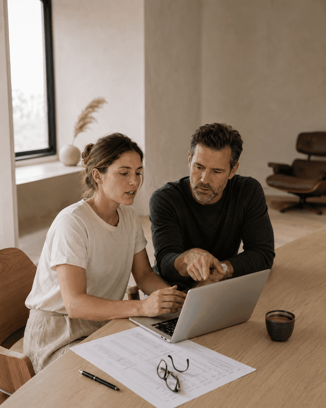 A consultant and client lead reviewing a working paper together at a laptop